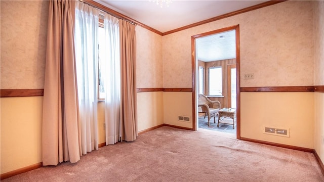 carpeted spare room featuring crown molding