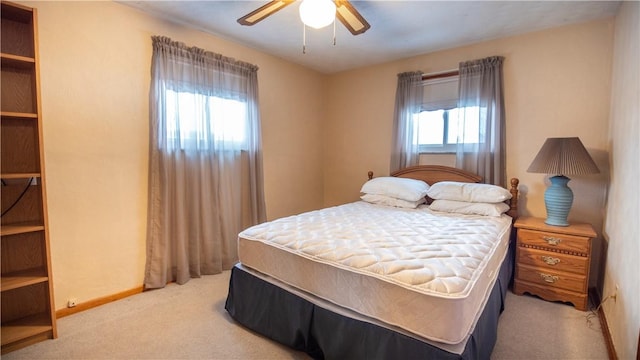 carpeted bedroom with ceiling fan and multiple windows