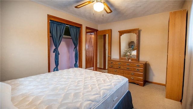 carpeted bedroom with a textured ceiling, ceiling fan, and a closet