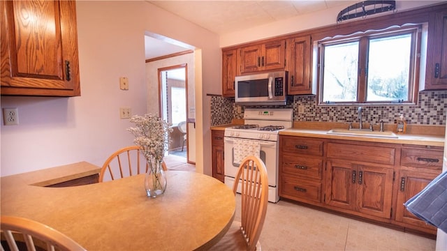 kitchen featuring decorative backsplash, sink, and white gas range