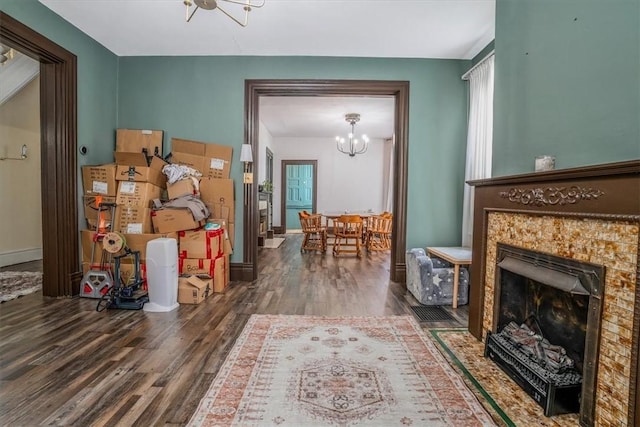 interior space featuring dark wood-type flooring, a chandelier, and a tiled fireplace