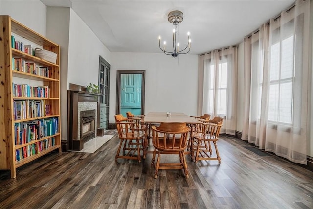 dining space with dark hardwood / wood-style floors and a notable chandelier