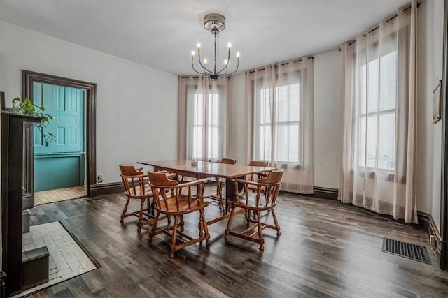 dining space featuring a notable chandelier and dark hardwood / wood-style floors