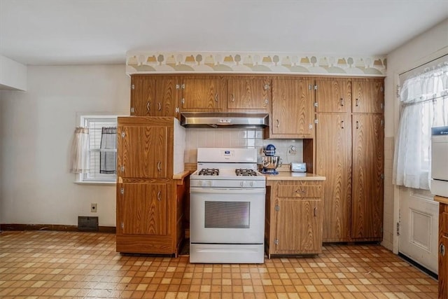 kitchen featuring decorative backsplash and white gas range oven