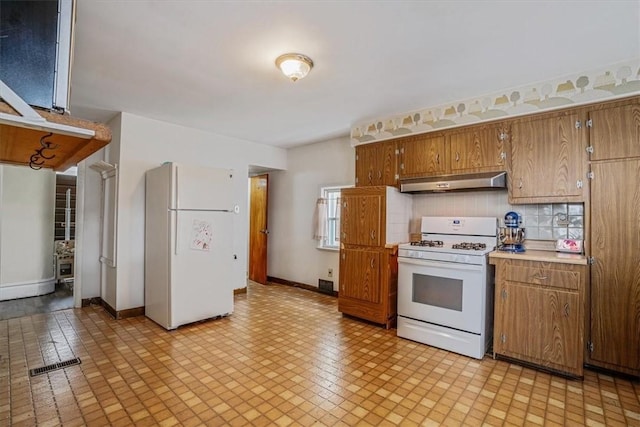 kitchen featuring decorative backsplash and white appliances