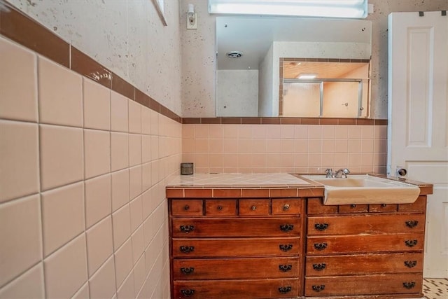 bathroom featuring tasteful backsplash, vanity, and tile walls