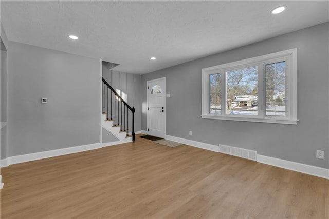 entrance foyer featuring light hardwood / wood-style floors and a textured ceiling