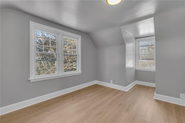 bonus room featuring a healthy amount of sunlight, lofted ceiling, and light hardwood / wood-style flooring