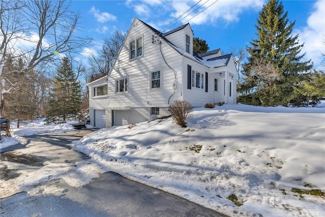 view of snow covered exterior featuring a garage