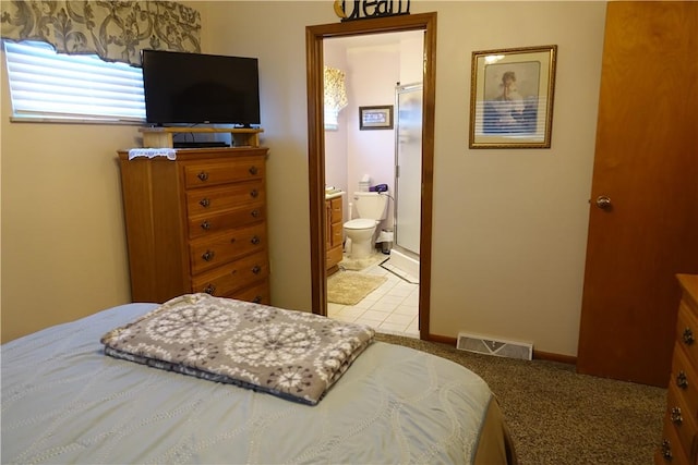 bedroom featuring light carpet and ensuite bath