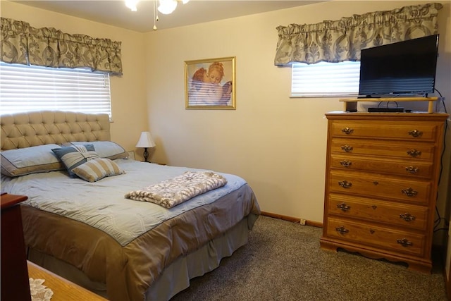 bedroom with multiple windows and dark carpet