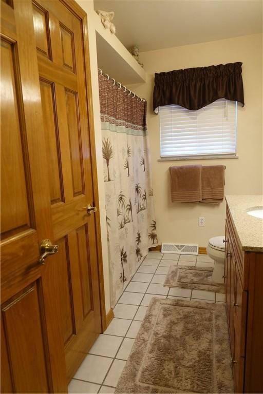 bathroom with toilet, tile patterned flooring, and vanity