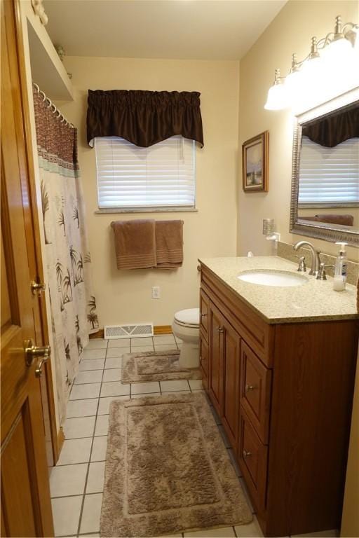 bathroom with toilet, tile patterned floors, and vanity