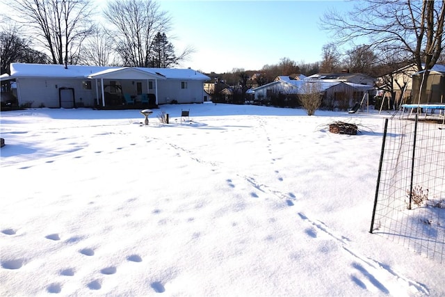 yard covered in snow with a trampoline