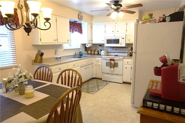 kitchen featuring white cabinetry, sink, ceiling fan with notable chandelier, and white appliances