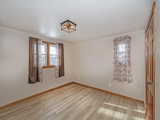 empty room with light hardwood / wood-style flooring