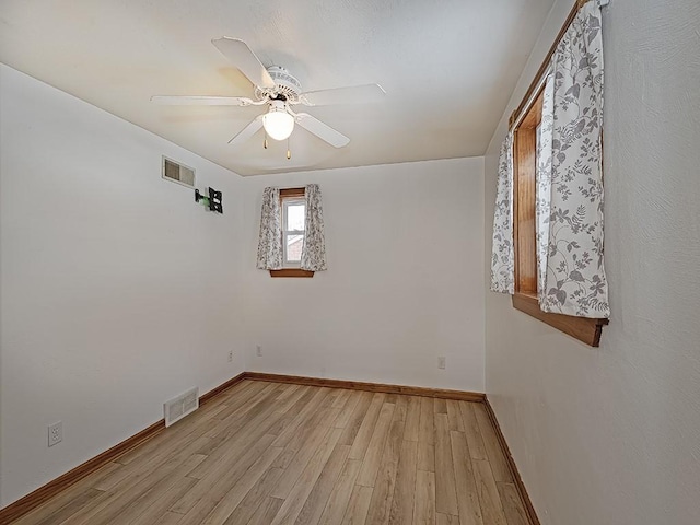 spare room with ceiling fan and light wood-type flooring