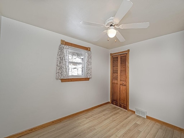 empty room with ceiling fan and light wood-type flooring