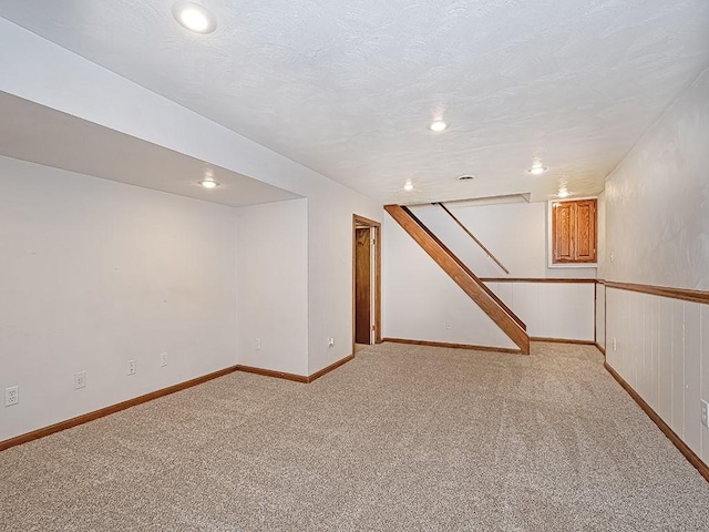 basement featuring light carpet and a textured ceiling