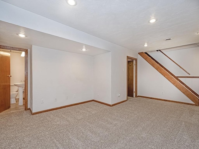 basement featuring a textured ceiling and carpet