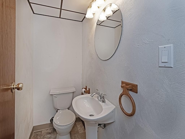 bathroom with sink, toilet, and tile patterned flooring