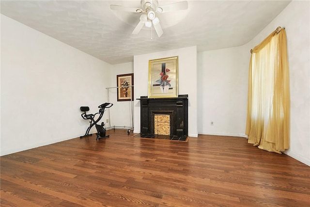 unfurnished living room with ceiling fan and dark wood-type flooring