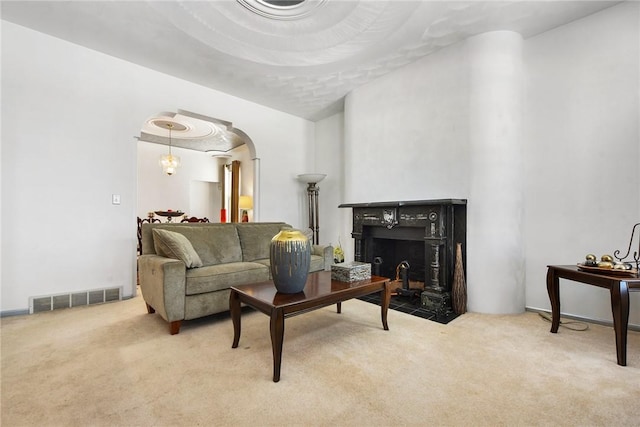 carpeted living room featuring a tile fireplace