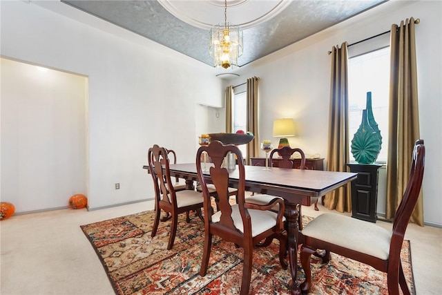 dining area with light carpet and an inviting chandelier