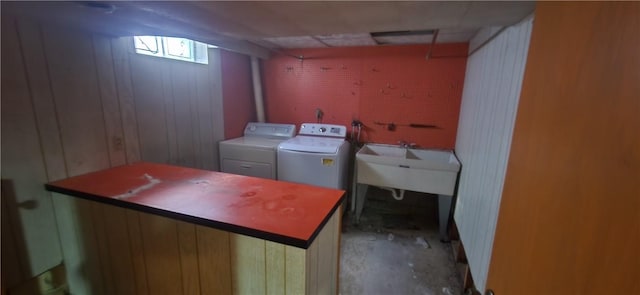 laundry area featuring separate washer and dryer and wood walls