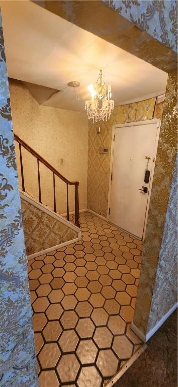 foyer entrance featuring a notable chandelier