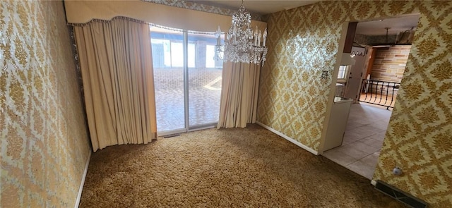 spare room featuring an inviting chandelier and carpet