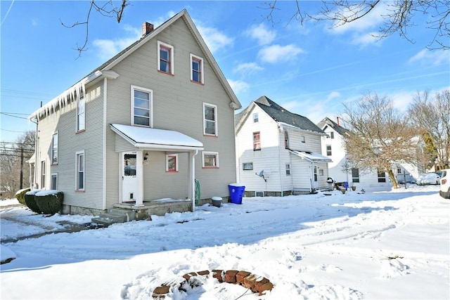 view of snow covered back of property