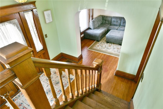 stairs featuring plenty of natural light and hardwood / wood-style floors