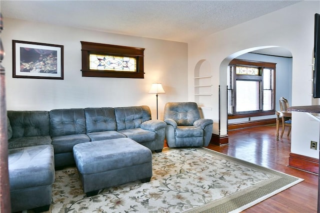 living room featuring hardwood / wood-style floors, built in features, and a textured ceiling