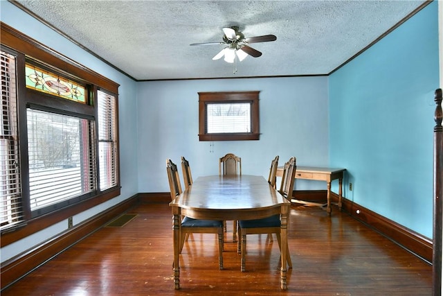 dining room featuring ceiling fan, a healthy amount of sunlight, dark wood-type flooring, and crown molding