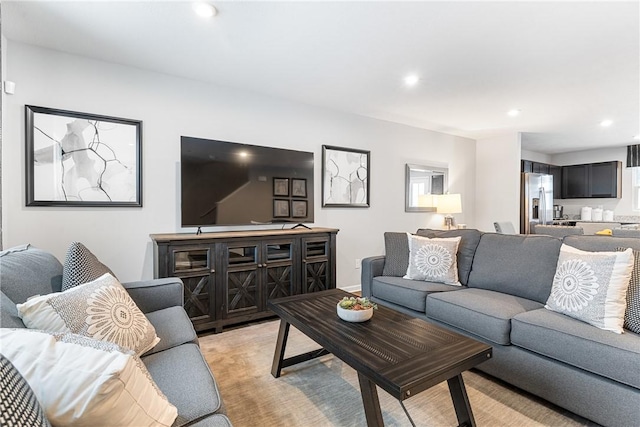 living area with recessed lighting and light carpet