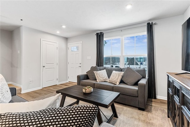 living room with light wood-style floors, recessed lighting, and baseboards