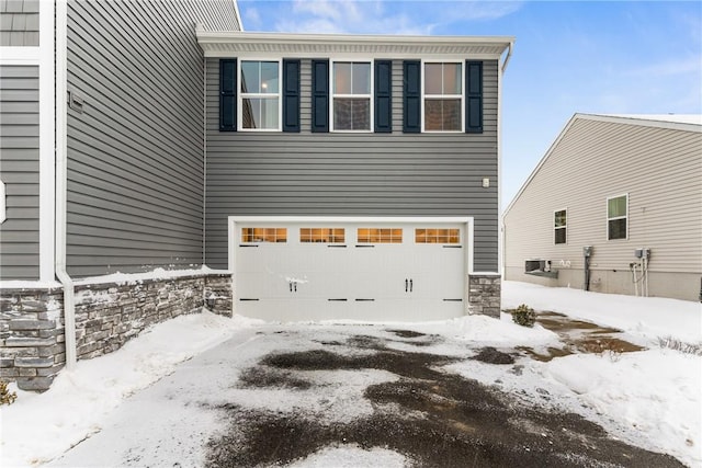 snow covered property featuring a garage