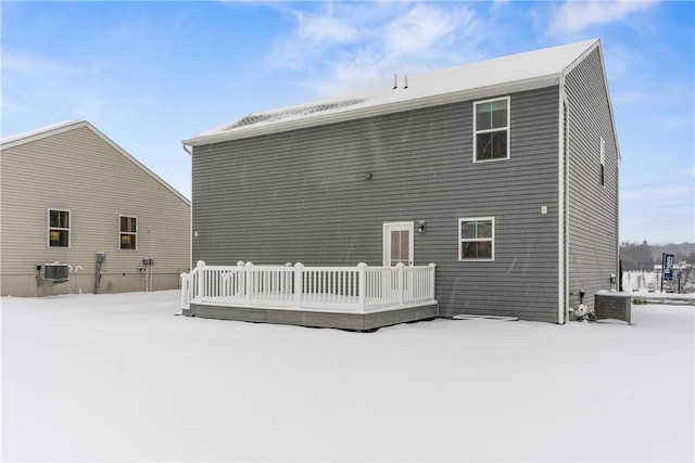 snow covered property with cooling unit and a deck