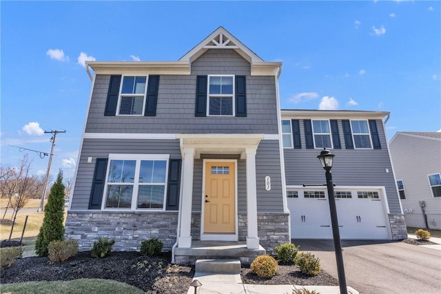 view of front of house featuring a garage, driveway, and stone siding