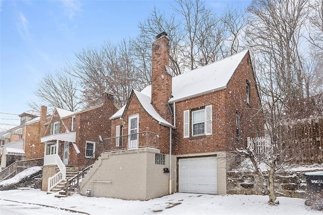 snow covered property with a garage