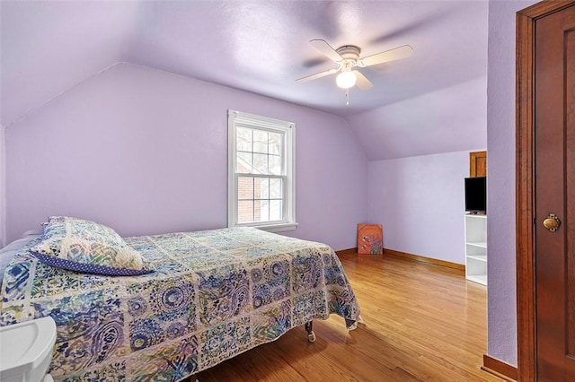 bedroom featuring light wood-type flooring, ceiling fan, and lofted ceiling