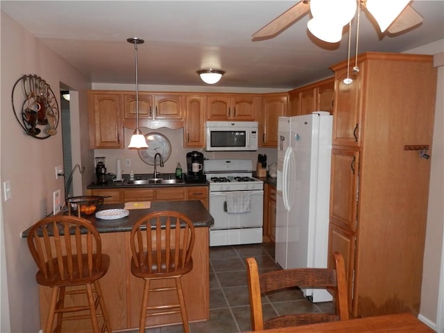 kitchen featuring decorative light fixtures, ceiling fan, sink, white appliances, and dark tile patterned floors