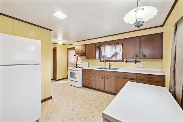 kitchen featuring decorative light fixtures, sink, and white appliances