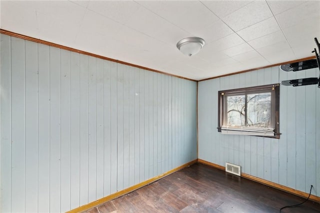 spare room featuring dark hardwood / wood-style flooring and crown molding