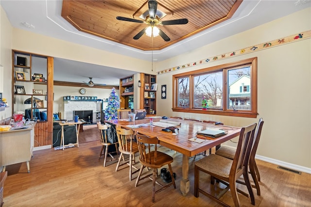 dining room featuring ceiling fan, wooden ceiling, and a raised ceiling