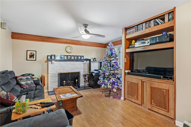 living room featuring ceiling fan, a fireplace, and light hardwood / wood-style floors