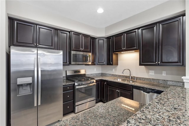 kitchen with sink, stainless steel appliances, and dark stone countertops