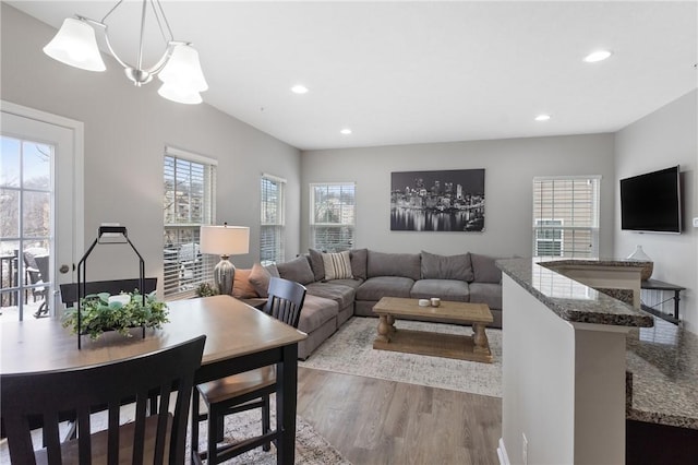 living room with light hardwood / wood-style flooring and an inviting chandelier