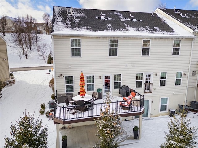 snow covered house featuring a deck and cooling unit